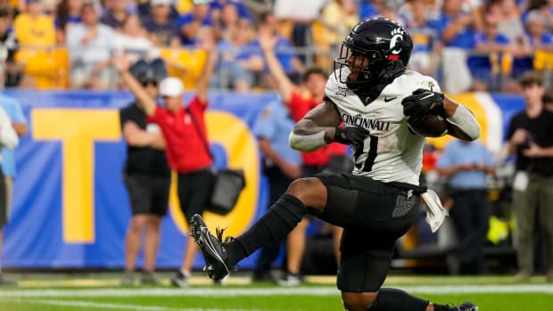 Cincinnati Bearcats running back Corey Kiner (21) breaks through the line for a touchdown in the second quarter of the NCAA football game between the Pittsburgh Panthers and the Cincinnati Bearcats at Acrisure Stadium in Pittsburgh on Saturday, Sept. 9, 2023. The Bearcats led 20-7 at halftime.